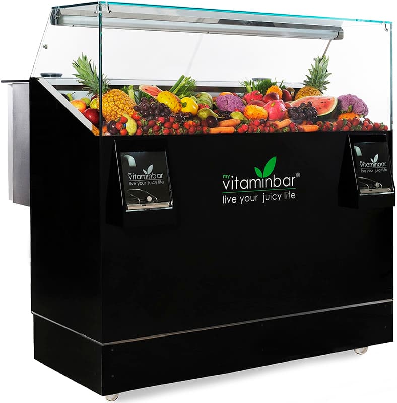 My Vitamin Bar dual juicer with a glass refrigerated display filled with fresh fruits and vegetables